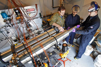 >Issam Mudawar, from left, a Purdue professor of mechanical engineering, discusses a hydrogen-storage system for cars with graduate student Milan Visaria and Timothée Pourpoint, an assistant professor of aeronautics and astronautics and manager of the Hydrogen Systems Laboratory