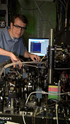 NIST postdoctoral researcher David Hanneke at the laser table used to demonstrate the first universal programmable processor for a potential quantum computer