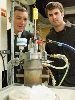 Professor Donald Sadoway and graduate student David Bradwell observe one of their small test batteries in the lab