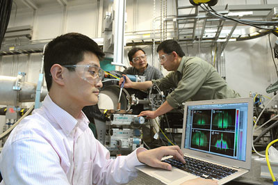 Assistant physicist Zhang Jiang (from left) examines a X-ray diffraction as physicist Jin Wang and nanoscientist Xiao-Min Lin prepare a sample at one of the Advanced Photon Source’s beamlines