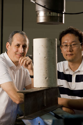 Scientists Pedro Alvarez (left) and Jaesang Lee stand behind a concrete cylinder and an I-beam, which is among the construction materials that manufacturers could potentially improve using certain nanomaterials. 