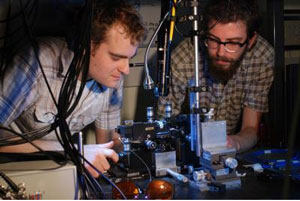 Research physicists Jonathan Matthews (left) and Kostas Poulios aligning the quantum optical chip. The photons are injected into the chip using optical fiber and requires precision alignment.