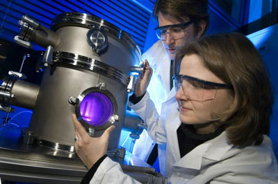 Scientists working with a plasma chamber