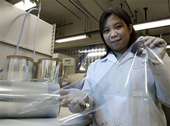A Tera-Barrier Films researcher displays a sample roll of the company's moisture-resistant protective coating