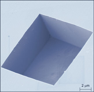 colorized electron microscope image reveals the boxy shape of the pits etched into the diamond surface