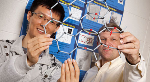 Physics Professor Michael Weinert and engineering graduate student Haihui Pu display the atomic structure on graphene monoxide
