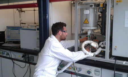 Doctoral candidate Elias Frei controls the temperature in the reactor of the catalyst test device