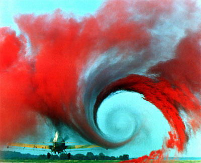 aerodynamics vortex with twisting red smoke produced by a rotating airplane