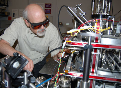 NIST researcher Jabez McClelland makes adjustments on the new magneto-optical trap ion source