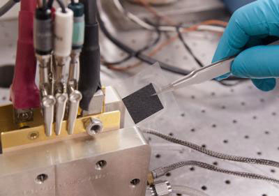 A membrane electrode assembly is being inserted into a fuel cell testing stand