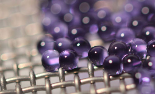 Microcapsules containing sodium carbonate solution are suspended on a mesh