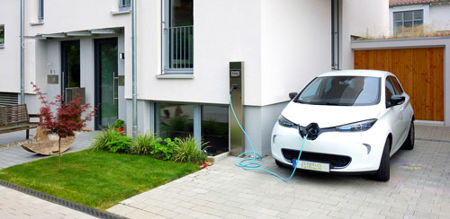 An electric vehicle is charged with photovoltaic power from the roof of the house using a charging station