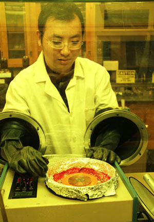 Ames Lab researcher Min Cai prepares a metal-oxide OLED