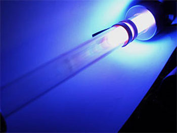 Light is emitted from excited argon gas atoms flowing through the glass tube of a plasma reactor