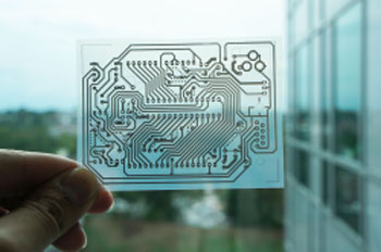A single-sided wiring pattern for an Arduino micro controller printed on a transparent sheet of coated PET film