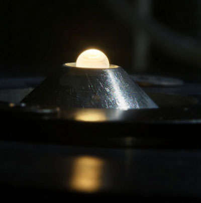 A metal oxide drop levitated in a flow of gas is heated from above with a laser beam