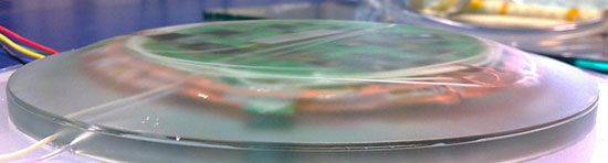 Interrogator after embedding in protective epoxy shell with shape optimized for minimal impact on composite structural strength