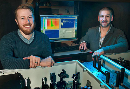 Postdoctoral fellow Erik Busby and Matt Sfeir with optical equipment they used to study charge carrier production in organic photovoltaic polymers