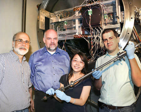 Pictured at the NOMAD instrument at Oak Ridge National Laboratory’s Spallation Neutron Source are David Wesolowski of the Chemical Sciences Division, Thomas Proffen of SNS, Hsiu-Wen Wang of JINS, and NOMAD instrument scientist Mikhail Feygenson. Wang and Feygenson are holding the NOMAD sample-mounting wand