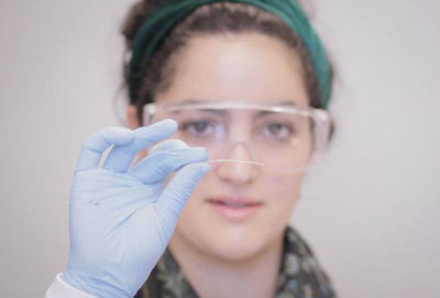 Christina Tringides, a senior at MIT and member of the research team, holds a sample of the multifunction fiber produced using the group’s new methodology