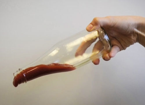 Ketchup slides out of a bottle that's been coated with LiquiGlide