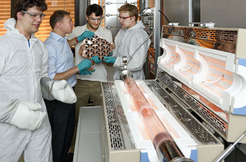 from left to right: Luca Banszerus, Christoph Stampfer, Michael Schmitz and Stephan Engels standing by the chemical vapour deposition oven in their laboratory