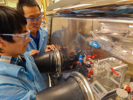 >From left, LLNL postdoc Jianchao Ye works on a lithium ion battery, while Morris Wang looks on