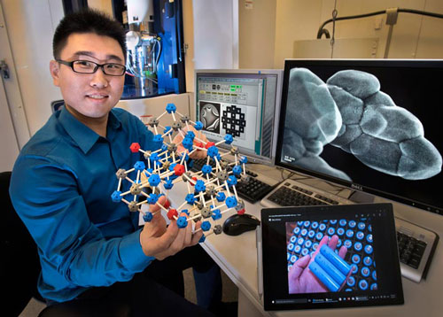 Brookhaven Lab physicist Huolin Xin in front of an aberration-corrected scanning transmission electron microscope