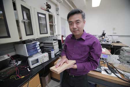 Associate Professor Xudong Wang holds a prototype of the researchers' energy harvesting technology, which uses wood pulp and harnesses nanofibers
