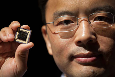 Wei Lu holds a memristor chip he created.
