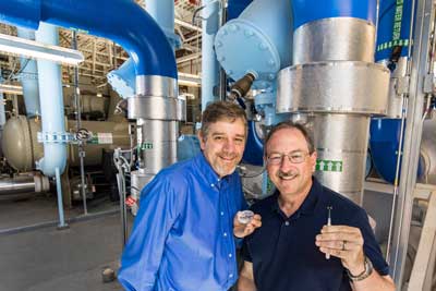 Sandia National Laboratories researchers Curtis Mowry, left, and Mike Siegal show their nanoporous carbon coated surface acoustic wave sensors