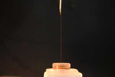 a chain of microparticles pulled out of the liquid by an electrode