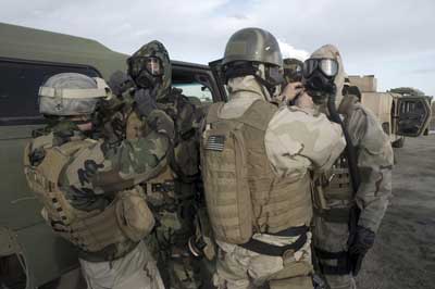Sailors assigned to Explosive Ordnance Disposal Unit (EODMU) 8 help each other don M-45 gas masks