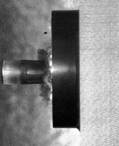 side image of a laboratory projectile impacting a ceramic disk backed by polycarbonate