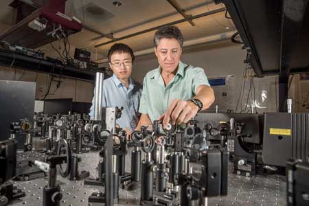 Yuanmu Yang, left, and Sandia researcher Igal Brener set up to do testing in an optical lab