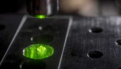 Single-crystal gem diamond sits on microscope under laser light