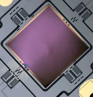 close-up view of a metasurface-based flat lens (square piece) integrated onto a MEMS scanner