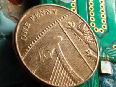 Quantum Random Number Generator Chip compared to a one penny coin