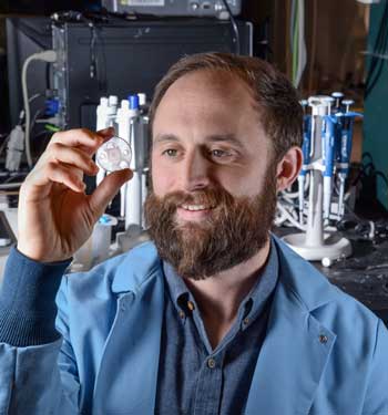 Sandia National Laboratories researcher Philip Miller examines a microneedle device