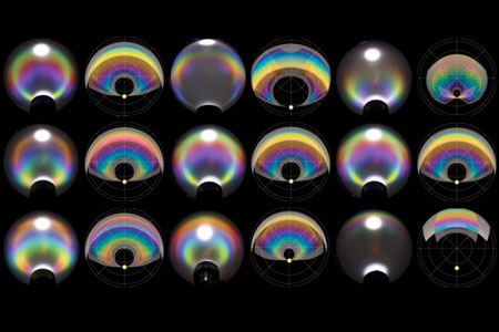 transparent droplets in a Petri dish, illuminated with white light, appear as varying colors