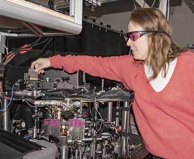 physicist Elizabeth Donley holds a card used to trace the paths of laser beams in the atomic gyroscope