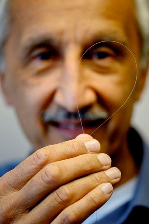 Jas Sanghera holds up optical fiber