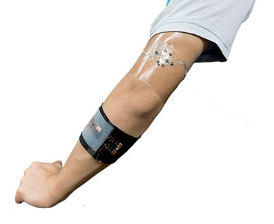 wearable biofuel cell applied to the arm, powering a diode attached to the black armband on the forearm