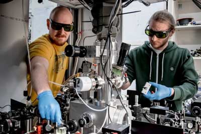 Researchers Kahan Dare (left) and Manuel Reisenbauer (right) working on the experiment that cooled a levitated nanoparticle to its motional quantum groundstate