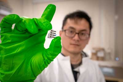 Qingzhen Bian holding a solar cell experiment