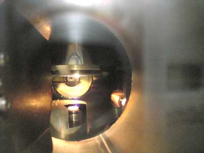 View through a metallic tube, an orange light shines at the end of the tube