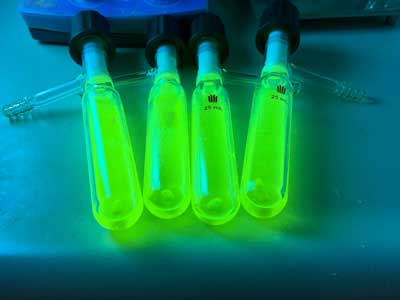 4 vials with intense green glow