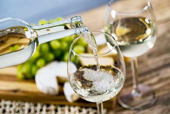 white wine nbeing poured into a glass