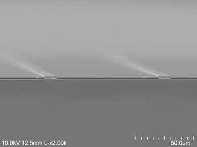 The electron microscope image shows the air (darkest gray) sandwiched between the gold backing at the bottom and the semiconductor at the top, supported on gold beams