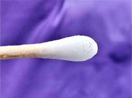 a swab with dozens of dust specks